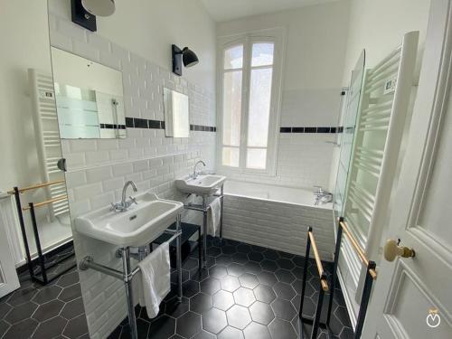 La salle de bains blanche est pourvue de 2 lavabos et d'une baignoire. dans l'établissement La Rose des Sables - Trouville sur Mer - 8P, à Trouville-sur-Mer