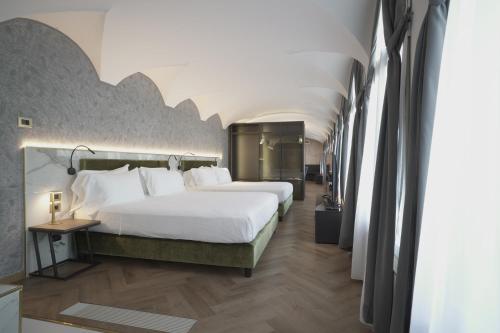 a hotel room with a large bed and a hallway at Palazzo Santo Spirito in Bergamo