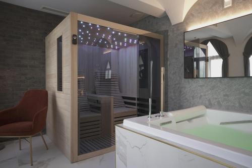 a bathroom with a tub and a chair and a mirror at Palazzo Santo Spirito in Bergamo