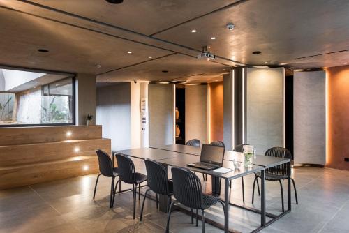 a dining room with a table with a laptop on it at Pilot Amphora Boutique Hotel "Adults Only" in Georgioupolis