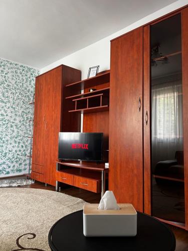 sala de estar con TV y armario de madera en Your cozy place en Târgu Mureș