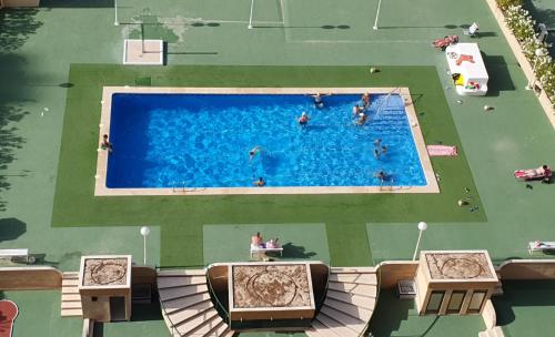 uma vista superior de uma piscina com pessoas nela em Mediterraneo 43 em Benidorm