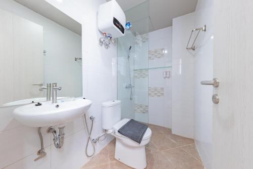 a bathroom with a toilet and a sink and a shower at Sans Hotel Berau Square in Tanjungredep