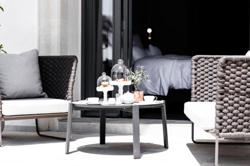 a living room with a table and two chairs and a bed at Sa Suites in Trepuzzi