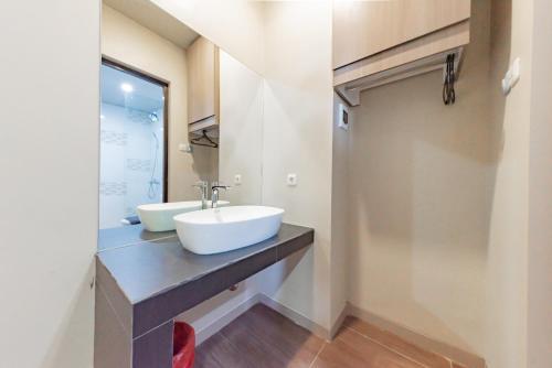 a bathroom with two sinks on a counter at Sans Hotel Berau Square in Tanjungredep