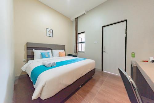 a bedroom with a large bed with two towels on it at Sans Hotel Berau Square in Tanjungredep