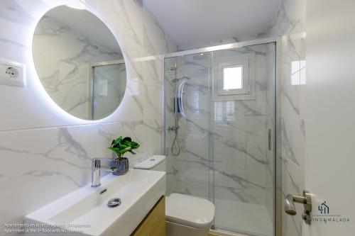 a bathroom with a shower and a sink and a mirror at Living4malaga Mi Carmela Beach in Málaga