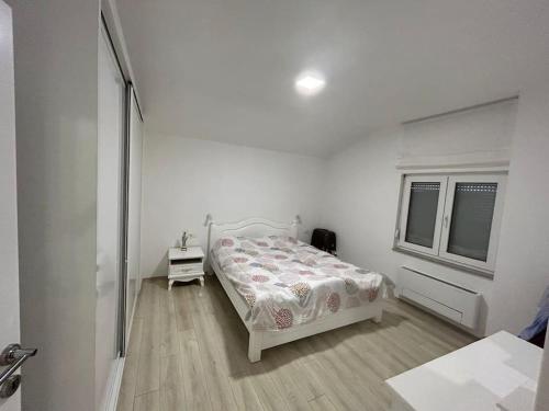 a white bedroom with a bed and a window at Beautiful Villa near Medjugorje in Služanj