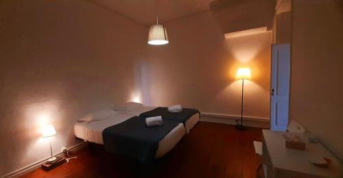 A Casa do Tenente في فارو: غرفة نوم مع سرير مع مصباحين