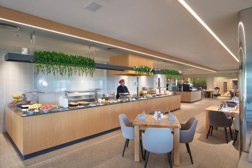 a restaurant with a chef standing behind a counter at Wine & SPA Hotel Chukara in Tryavna