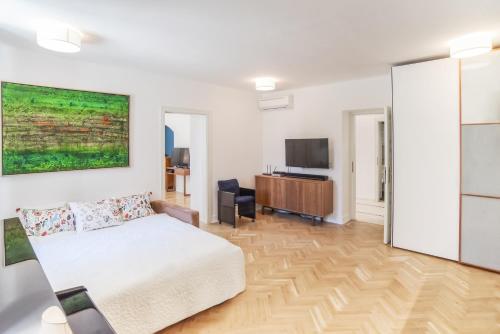 a living room with a bed and a television at Garden View Apartment in Budapest
