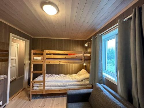 a bedroom with two bunk beds and a couch at Hytte med flott utsikt in Beitostøl