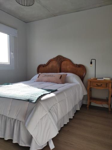 a bedroom with a large bed with a wooden headboard at Apartamento centrico in Minas