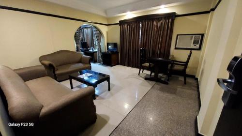 a living room with a couch and a table at Lytton Hotel in Kolkata