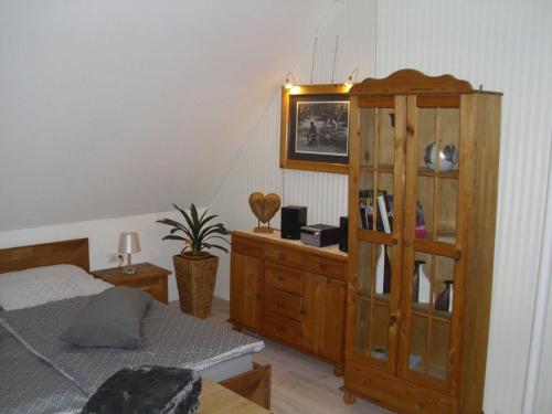 1 dormitorio con 1 cama y armario de madera en Ferienzimmer Am Stadtrand, en Dwasieden
