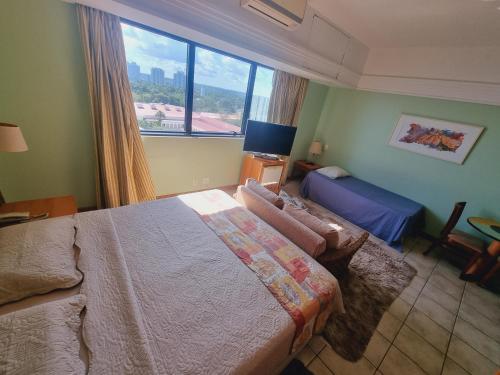 a bedroom with a bed and a large window at Tropical Executive Flat Vista Maravilhosa do Rio in Manaus
