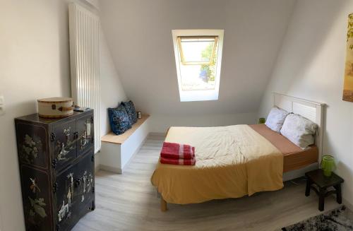 une chambre avec un lit, une commode et une fenêtre dans l'établissement Chambre chez l'habitant 
