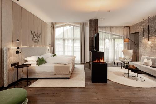 a living room with a bed and a fireplace at The Laurin Small & Charming in Selva di Val Gardena