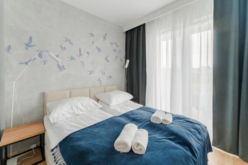 a bedroom with a bed with blue birds on the wall at Apartament BIRDS SurfingBird Dźwirzyno in Dźwirzyno