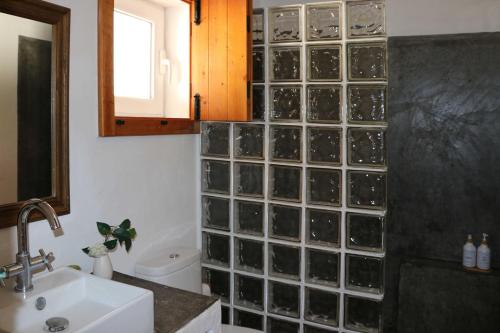 uma casa de banho com uma parede com um bloco de vidro, um WC e um lavatório. em Monte da Casa Nova - Jul and Ago only 7 days stays check-in and check-out on Saturdays em Vale de Água