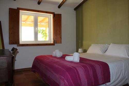 1 dormitorio con 1 cama con 2 toallas en Monte da Casa Nova - Jul and Ago only 7 days stays check-in and check-out on Saturdays, en Vale de Água