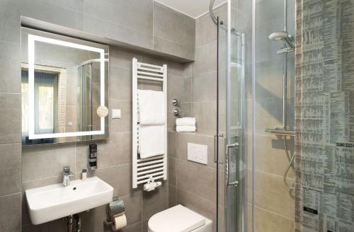 a bathroom with a toilet and a sink and a shower at tinyTwice Hotel Bonn in Bonn