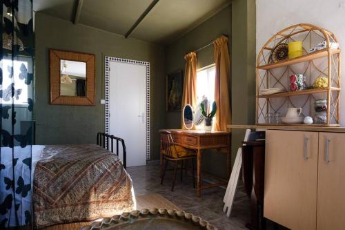 - une chambre avec un lit, un bureau et une table dans l'établissement Finca Martina, à Casarabonela