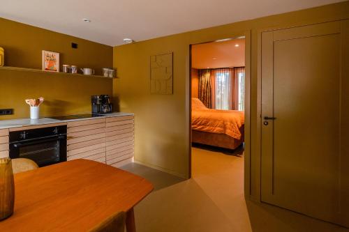 a kitchen with yellow walls and a bedroom with a bed at Residenties en bungalow Royal Domburg in Domburg