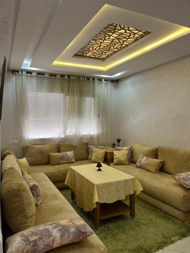 a living room with a couch and a table at Appartement de luxe, Tanagra Mall in Kenitra