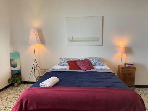 1 dormitorio con 1 cama con sábanas azules y almohadas rojas en Villa Vento Largo, Casa Marina, en Ventimiglia