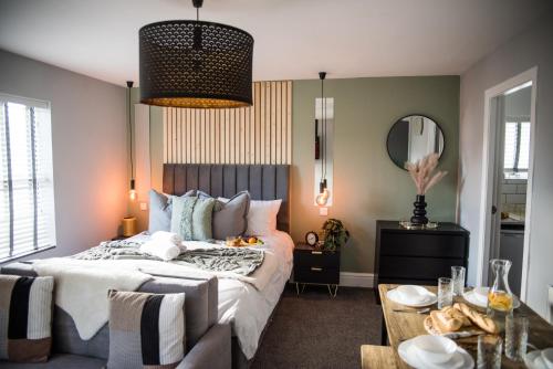 a bedroom with a bed and a table and a mirror at Blackpool Abode - Coastel Suite Apartment in Blackpool