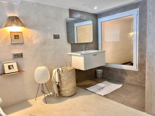 a bathroom with a sink and a mirror and a chair at The Cliff Appartment in Dar Mimoun Bey