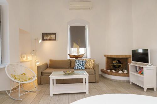 a living room with a couch and a tv at Gaia accomodation Hydras in Hydra