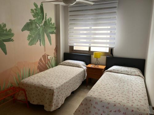 sypialnia z 2 łóżkami i oknem w obiekcie Apartamento Paseo Marítimo Antonio Banderas w Maladze
