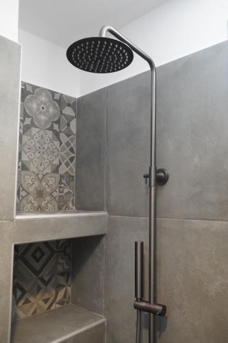 a shower with a shower head in a bathroom at Azul Houses Kythnos in Kithnos