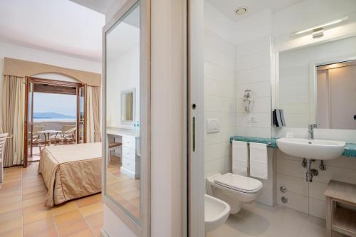 ein Badezimmer mit Toilette und Waschbecken in der Unterkunft Hotel Punta Negra in Alghero