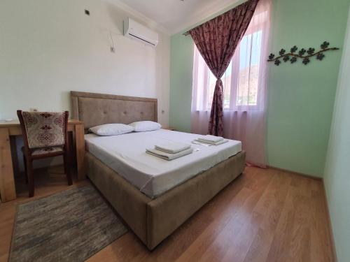 a bedroom with a bed and a window and a chair at Siran Guest House in Areni