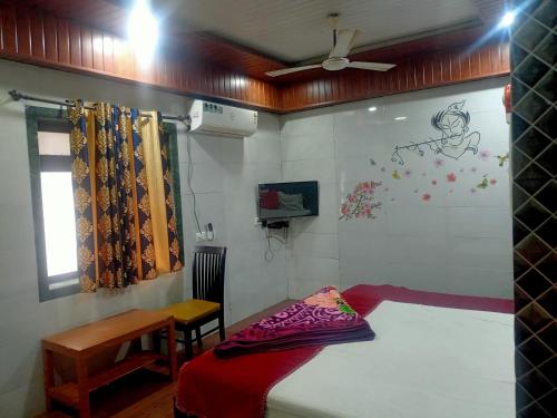 a bedroom with a bed and a table and a window at Hotel Geetanjali St Bus Stand Panvel in Panvel