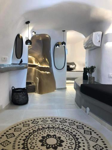 a bathroom with two mirrors and a bed and a rug at Marann Cave in Akrotiri