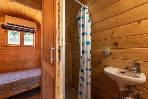ein Badezimmer mit einem Waschbecken und einer Dusche in einem Blockhaus in der Unterkunft Terreditusa - Bungalow Lavanda in Tusa
