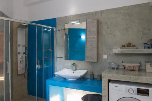 a bathroom with a sink and a washing machine at ΠΙΘΟΣ ΕΝΟΙΚΙΑΖΟΜΕΝΗ ΚΑΤΟΙΚΙΑ in Kalamata