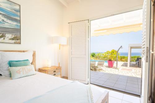 1 dormitorio con cama y vistas al océano en Villa Margaux en Grand-Bourg