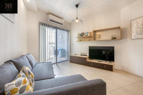 sala de estar con sofá y TV de pantalla plana en Wonderful, designer 2BR home with large Sofa & TV by 360 Estates, en San Julián