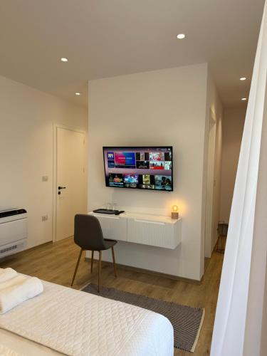 1 dormitorio con escritorio y TV en la pared en Hotel Restaurant Natyra e Qetë en Lezhë