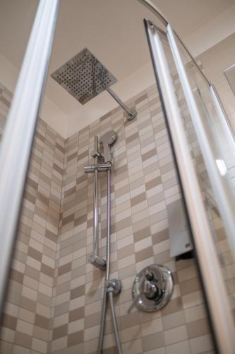 a shower in a bathroom with a tiled floor at Hotel Punta Negra in Alghero