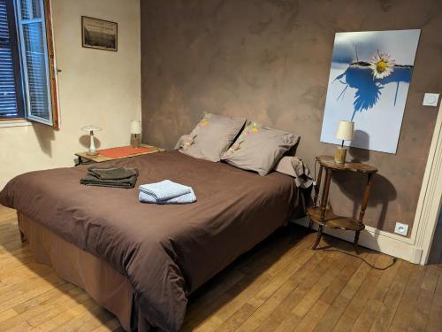 une chambre avec un lit et une table avec une lampe dans l'établissement Gîte Pierre et Marie, à Mellecey