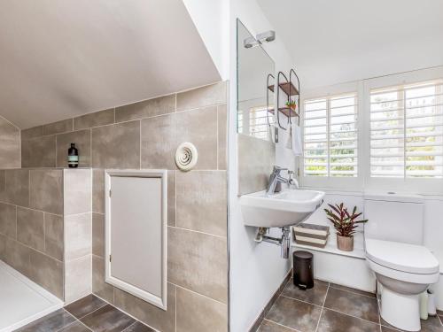 a bathroom with a sink and a toilet and a tub at Pass the Keys Charming Cottage with Garden in Chichester
