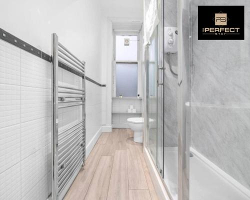 a white bathroom with a toilet and a shower at Glasgow Airport Luxury Apartment By Your Perferct Stay Short lets Glasgow in Paisley