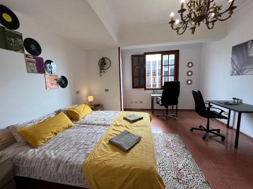 1 dormitorio con 1 cama, mesa y sillas en CoLiving El Secretario, en Las Palmas de Gran Canaria