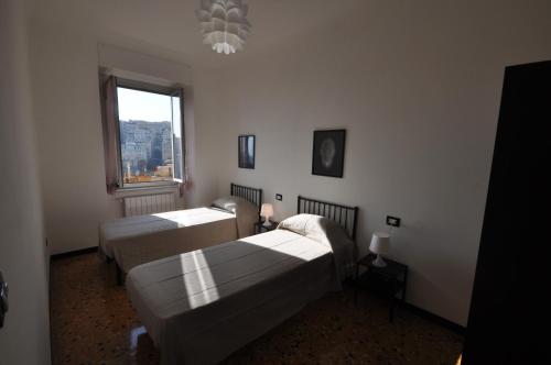- une chambre avec 2 lits et une fenêtre dans l'établissement Perdianahouse Waterfront, à Gênes